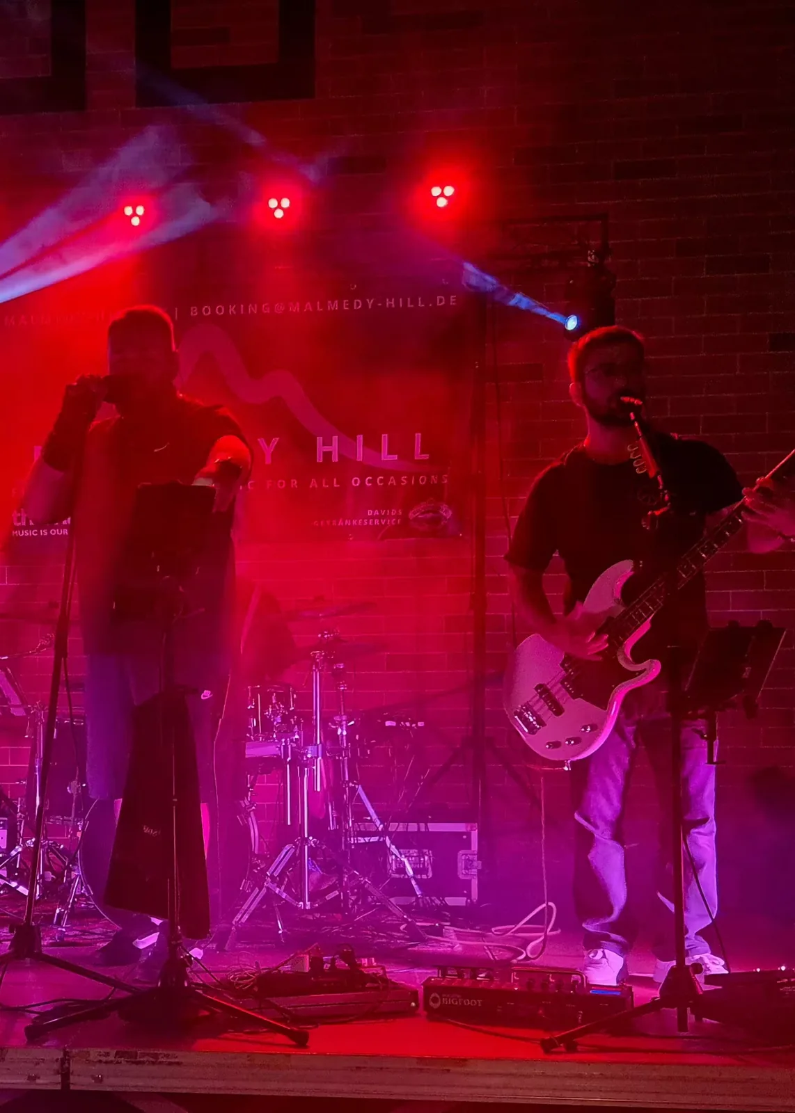 Sänger und Bassist von Malmedy Hill im roten Bühnenlicht